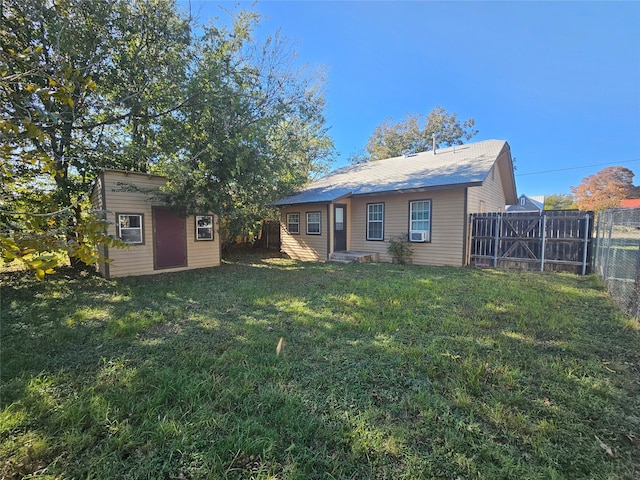 back of house featuring a yard and an outbuilding