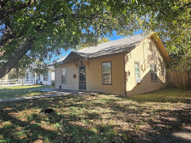 view of front facade with cooling unit and a front lawn