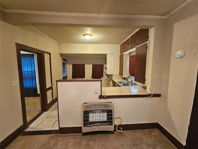 kitchen with tile counters, light colored carpet, sink, and heating unit