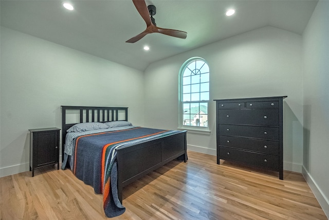 bedroom with ceiling fan, light hardwood / wood-style flooring, and vaulted ceiling