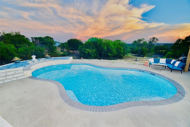 pool at dusk featuring a patio