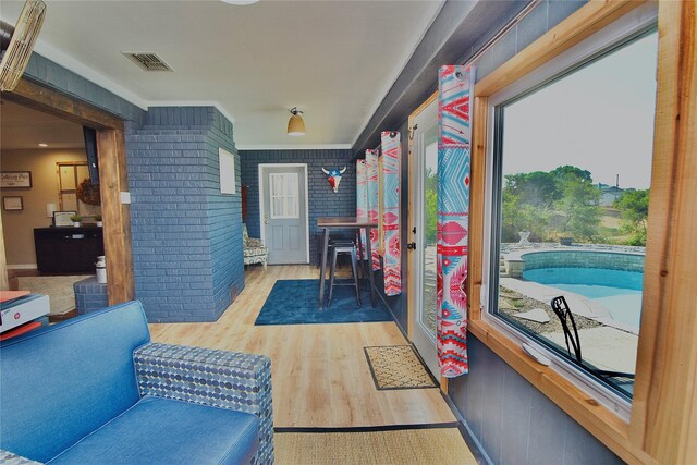 game room featuring light hardwood / wood-style flooring and brick wall