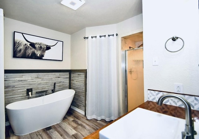 bathroom featuring sink, wood-type flooring, and shower with separate bathtub