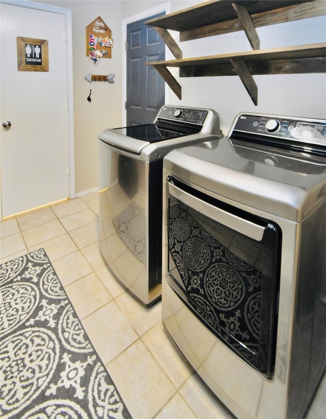 washroom with washing machine and dryer and light tile patterned floors