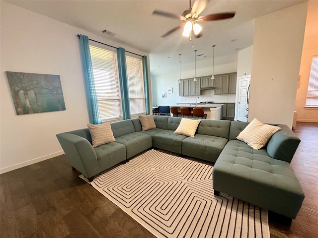 living room featuring ceiling fan and dark wood-type flooring