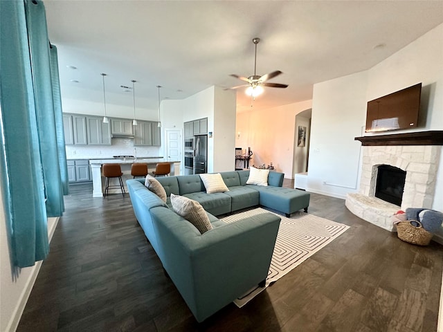 living room featuring a fireplace, dark hardwood / wood-style floors, and ceiling fan