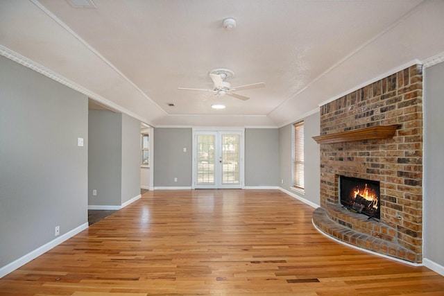 unfurnished living room with crown molding, a fireplace, light hardwood / wood-style floors, and ceiling fan