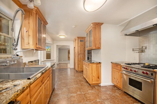 kitchen with light stone counters, sink, tasteful backsplash, and appliances with stainless steel finishes