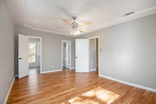 empty room with ceiling fan and light hardwood / wood-style floors