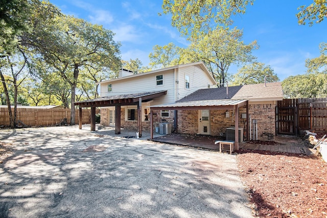 rear view of property featuring central AC unit and a patio area