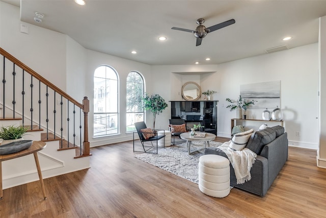 living room featuring ceiling fan and light hardwood / wood-style flooring