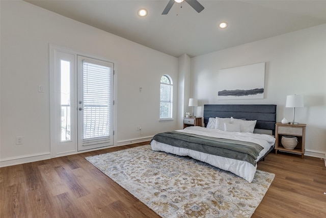 bedroom featuring hardwood / wood-style floors, access to outside, multiple windows, and ceiling fan