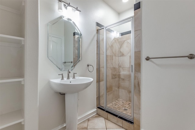 bathroom featuring tile patterned flooring, an enclosed shower, and sink