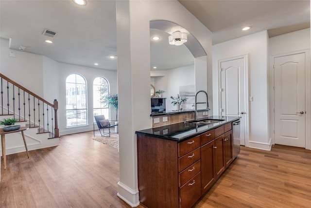 kitchen with dishwasher, sink, and light hardwood / wood-style floors