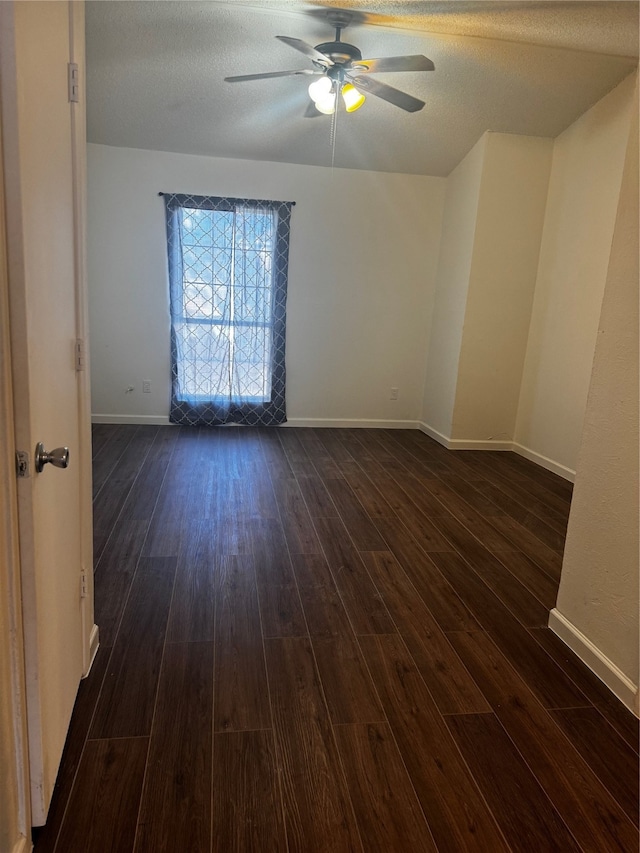 empty room featuring ceiling fan, dark hardwood / wood-style flooring, and a textured ceiling