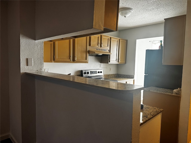 kitchen with kitchen peninsula, a textured ceiling, stainless steel stove, and fridge