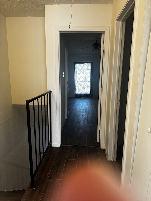 hall with dark hardwood / wood-style floors and a textured ceiling