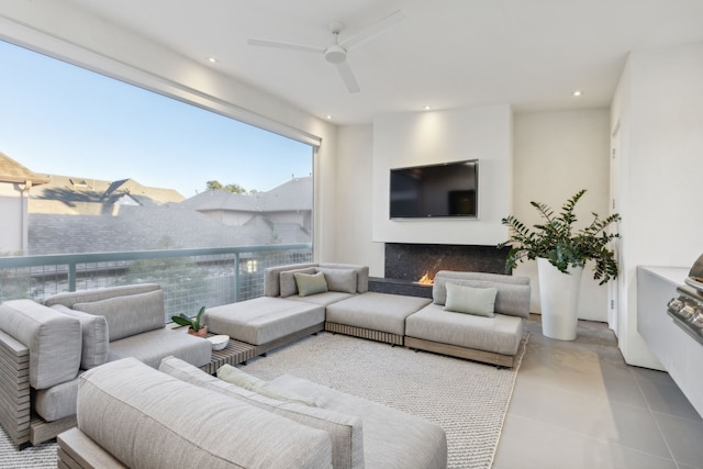 living room with tile patterned floors, ceiling fan, and a fireplace