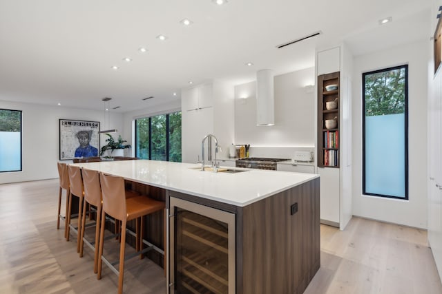 5103 Vickery Blvd, Dallas, TX 75206 - kitchen with wine cooler, modern cabinets, light wood-type flooring, white cabinets, and recessed lighting