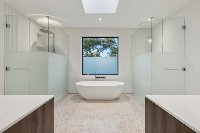 bathroom with vanity, separate shower and tub, and a skylight