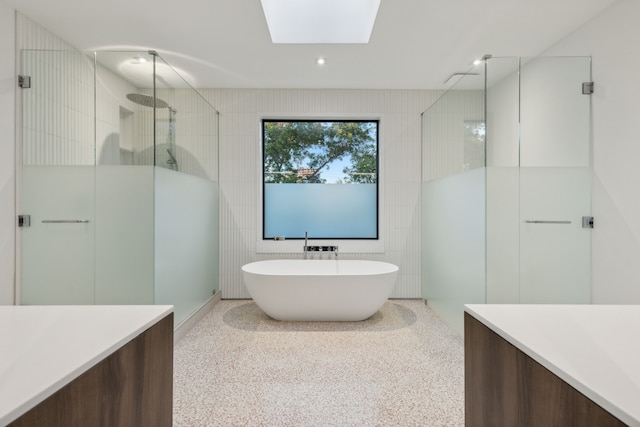 5103 Vickery Blvd, Dallas, TX 75206 - bathroom featuring a shower with shower door, speckled floor, a soaking tub, a skylight, and vanity