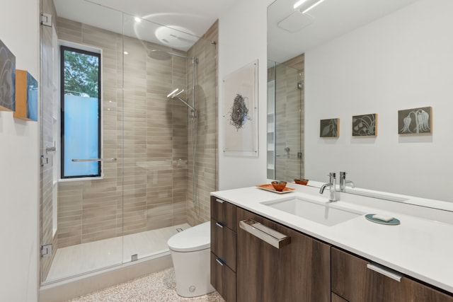 bathroom with vanity, toilet, and a shower with door