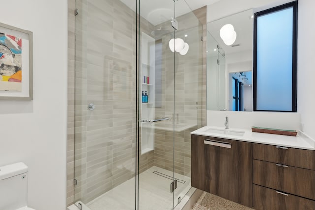 bathroom with vanity, toilet, and a shower with shower door