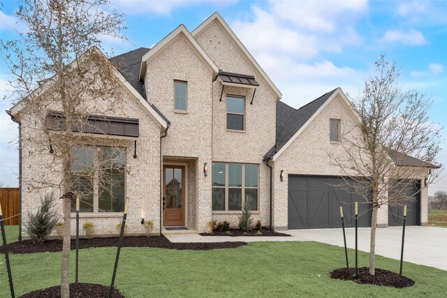 view of front of property with a garage and a front lawn