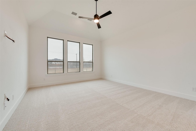 spare room with vaulted ceiling, light carpet, and ceiling fan