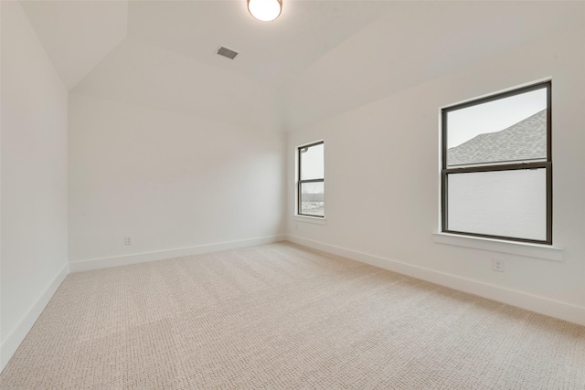 spare room featuring lofted ceiling and carpet