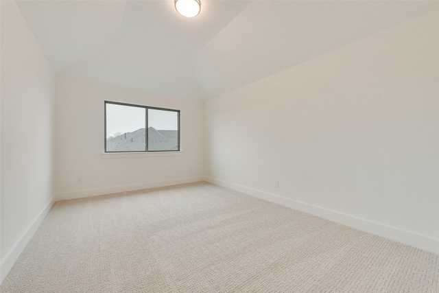 empty room with vaulted ceiling and light carpet