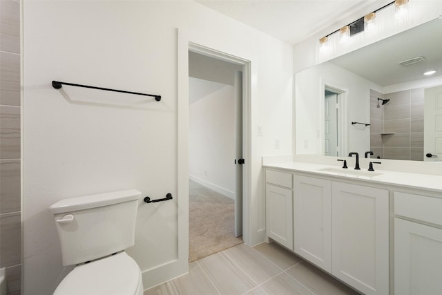 bathroom featuring vanity, toilet, and tiled shower