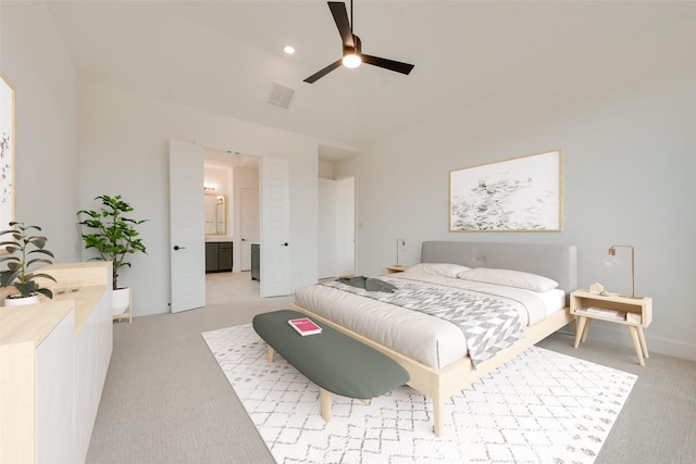 bedroom featuring connected bathroom, vaulted ceiling, light colored carpet, and ceiling fan