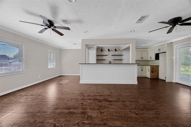 unfurnished living room featuring dark hardwood / wood-style flooring, plenty of natural light, and a textured ceiling