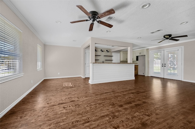 unfurnished living room with plenty of natural light, dark wood-type flooring, and a textured ceiling