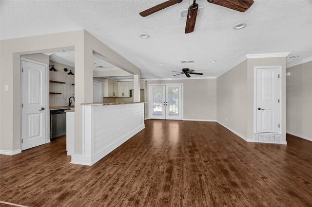 unfurnished living room featuring french doors, a textured ceiling, dark hardwood / wood-style floors, and crown molding