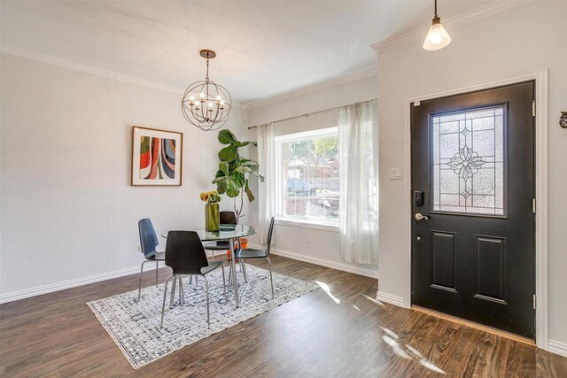 entrance foyer featuring an inviting chandelier, dark wood-type flooring, and ornamental molding