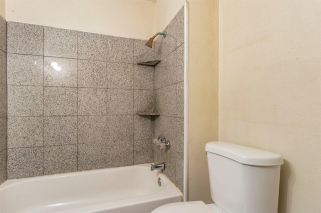 bathroom featuring tiled shower / bath combo and toilet