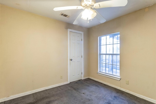 unfurnished room with dark colored carpet and ceiling fan