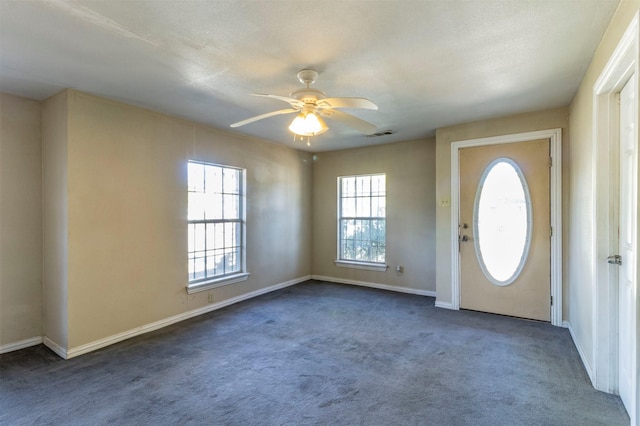 entryway featuring ceiling fan and dark carpet