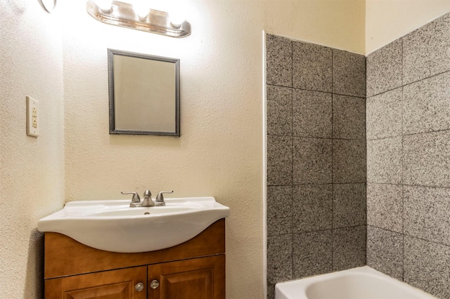 bathroom with a tub and vanity