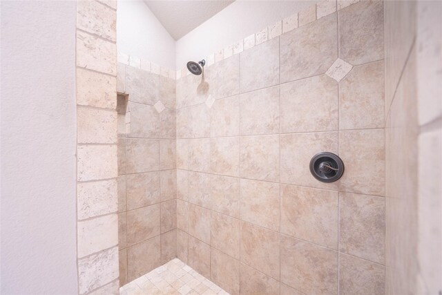 bathroom with tiled shower and lofted ceiling