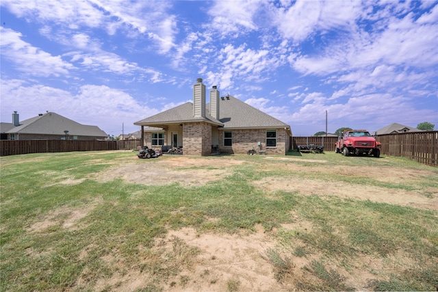 rear view of property with a lawn