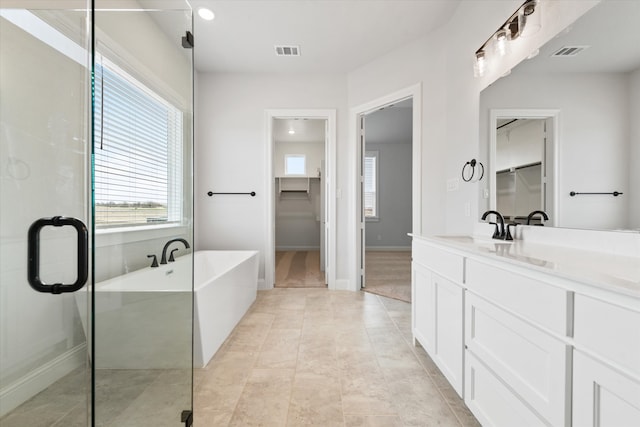 bathroom with tile patterned floors, vanity, and shower with separate bathtub