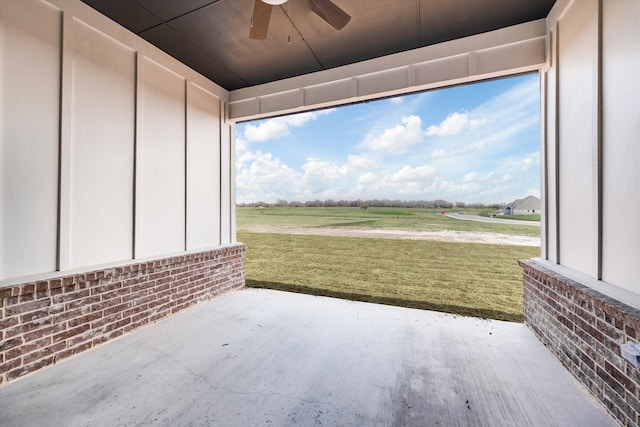 view of patio / terrace featuring ceiling fan and a rural view