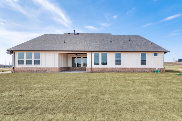 back of property with a yard and ceiling fan