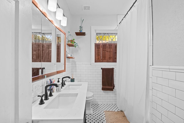 bathroom with tile patterned flooring, toilet, vanity, tile walls, and a shower with shower curtain