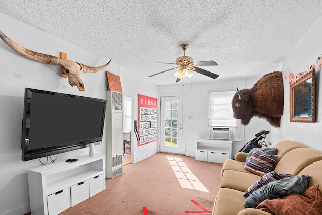 living room with cooling unit, light carpet, ceiling fan, and a textured ceiling