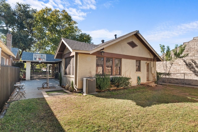 back of property with a patio, a lawn, and central air condition unit