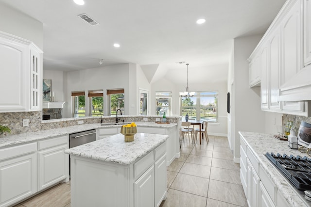 kitchen with decorative backsplash, a kitchen island, kitchen peninsula, and white cabinetry